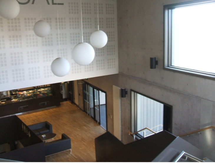 Modern interior atrium with pendant lighting and concrete walls