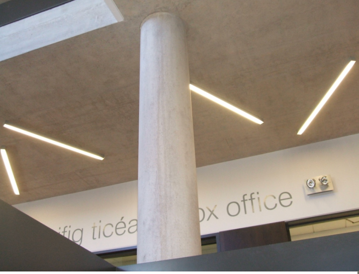 Concrete column and ceiling with linear lighting at theatre box office