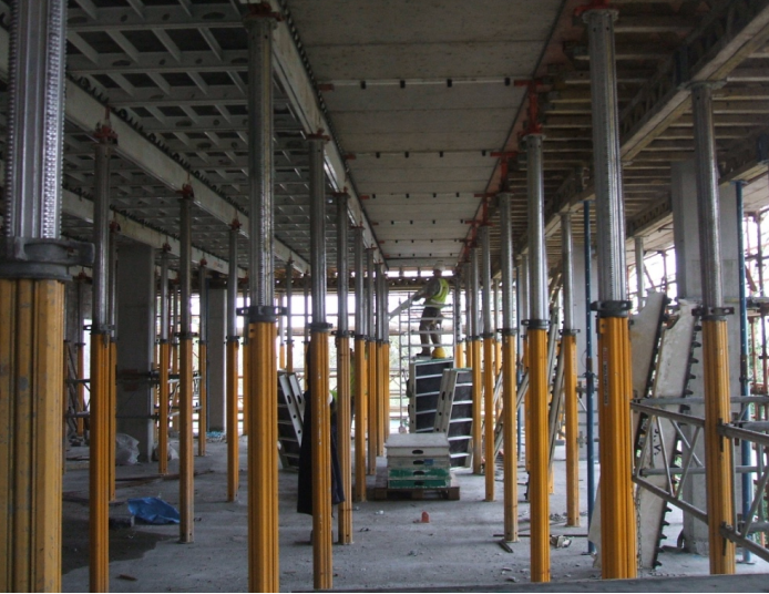 Interior formwork with yellow props supporting concrete slab mid-construction