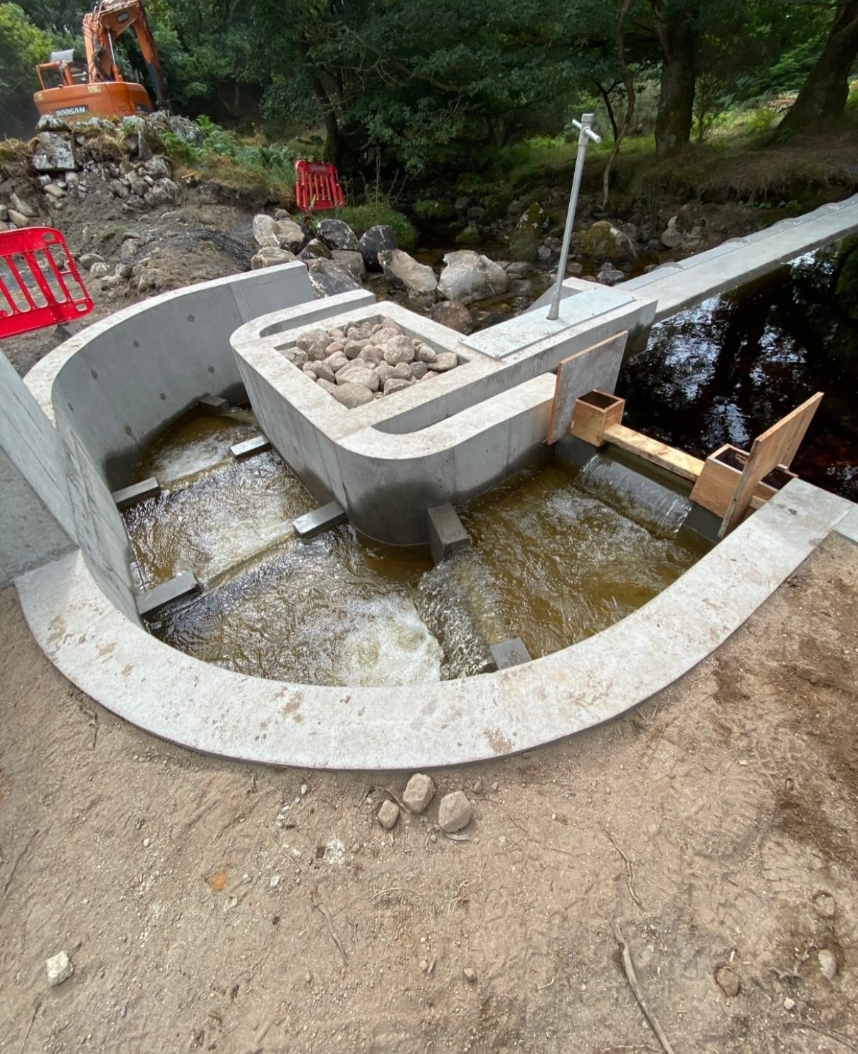 Completed circular fish pass pool with flowing water