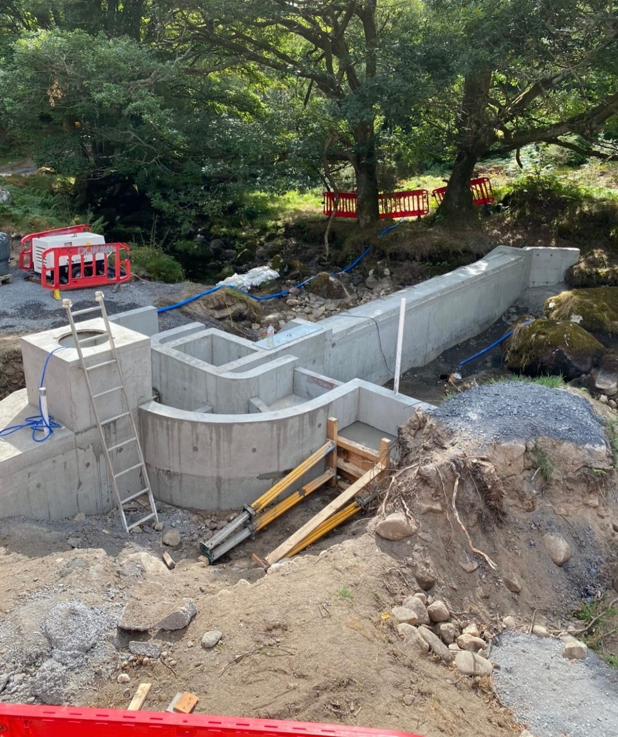 Concrete weir walls and fish pass structure mid-construction